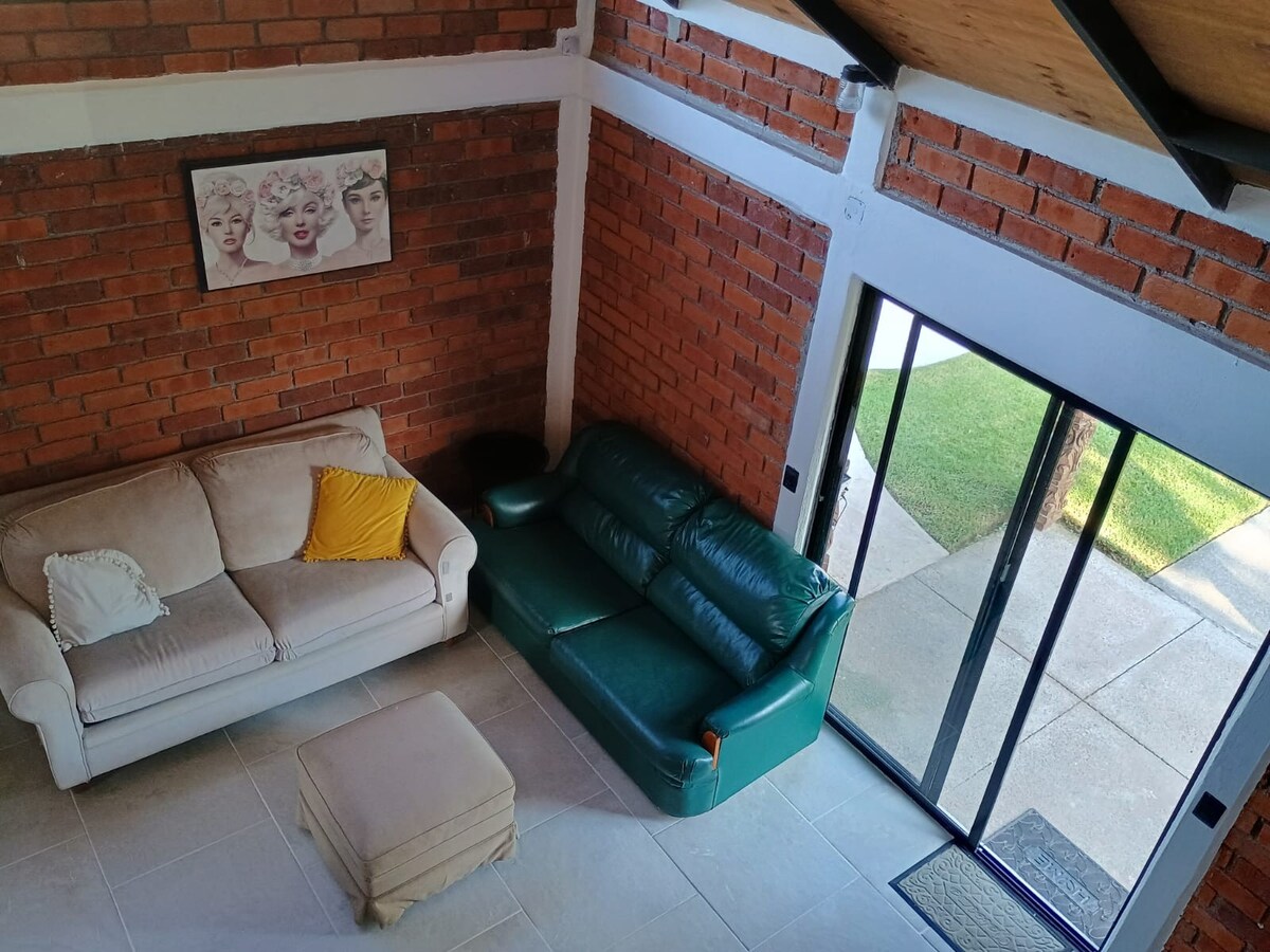Sala del quiosco con sofás y vista al jardín a través de puertas corredizas