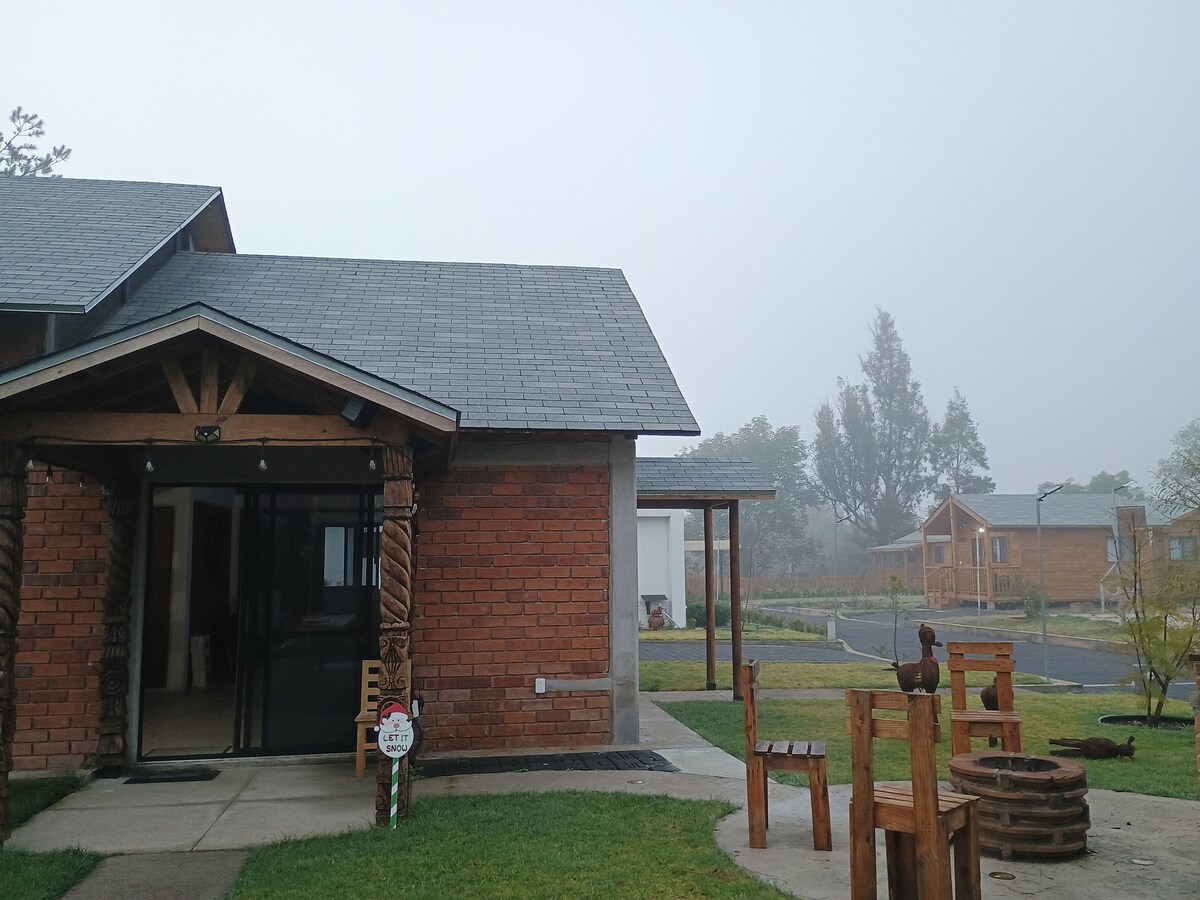 Entrada de la cabaña en una mañana de niebla