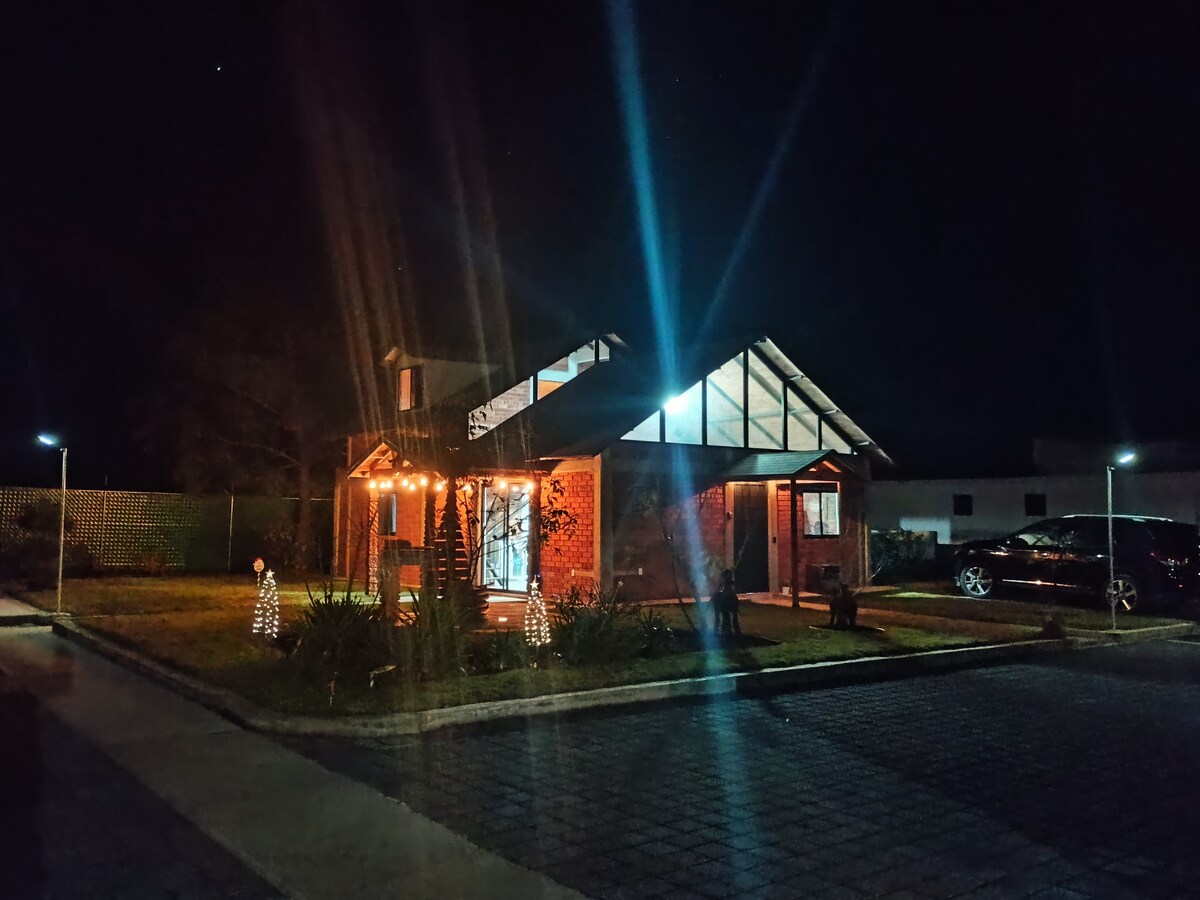 Cabaña iluminada de noche con luces cálidas y árbol decorado
